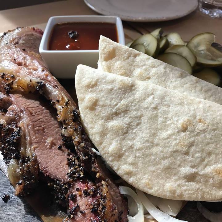A huge plate of brisket, tortillas, and pickles