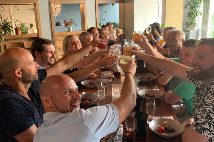 a group of people are drinking from a wine glass