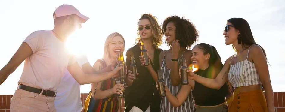 a couple of people are drinking from a wine glass