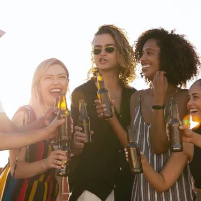 a couple of people are drinking from a wine glass