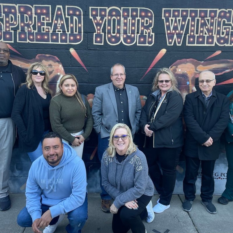 group posing in front of mural