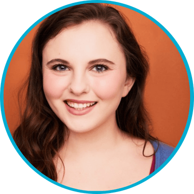 Smiling person with long hair against orange background.
